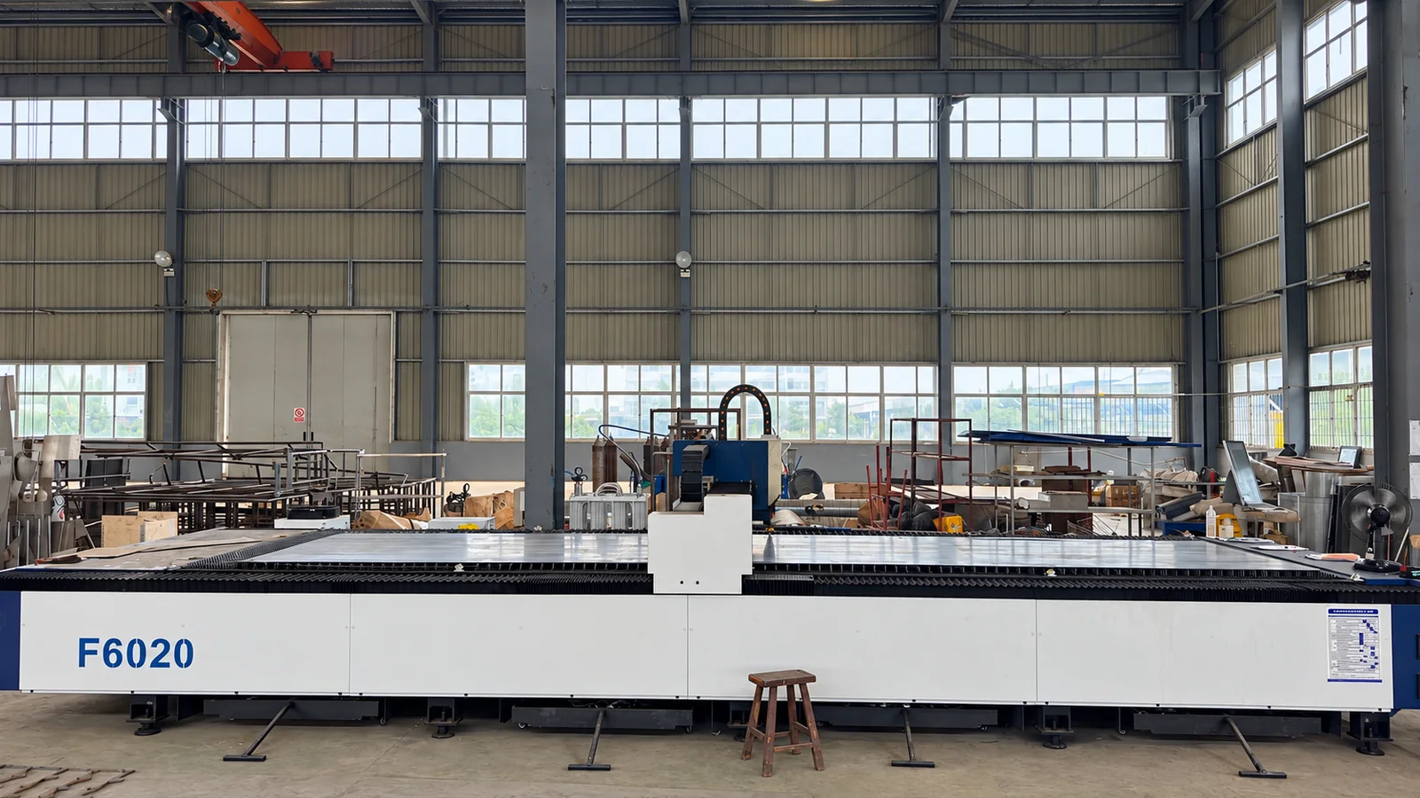 Open-bed cutting machine with a central cutting head in the workshop