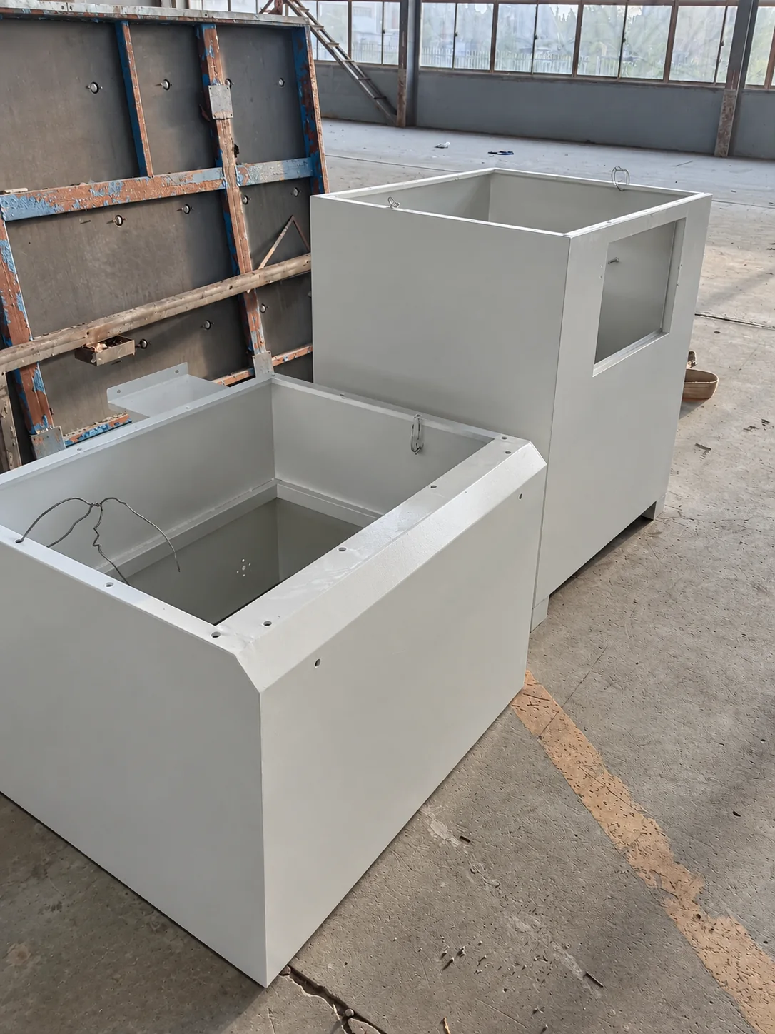 Overview of two painted metal enclosures with open tops